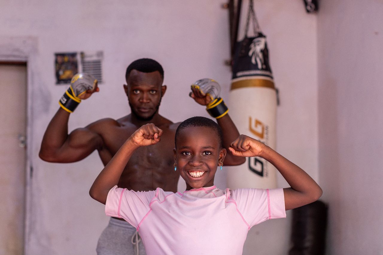 Coach and young student flexing